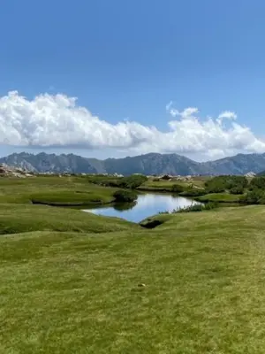 a view of a golf course with a pond at Casa linsia in Aléria