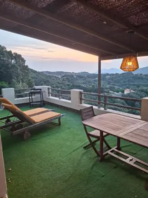 a patio with a table and chairs on a roof at Le Gîte Radica in Eccica-Suarella