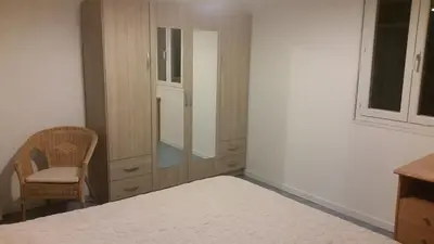 a bedroom with a bed and a mirror and a chair at Le Gîte Radica in Eccica-Suarella