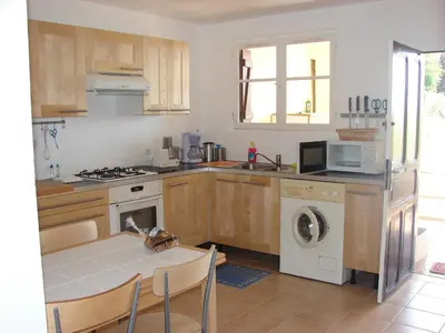 a kitchen with a table and a stove and a microwave at Le Gîte Radica in Eccica-Suarella