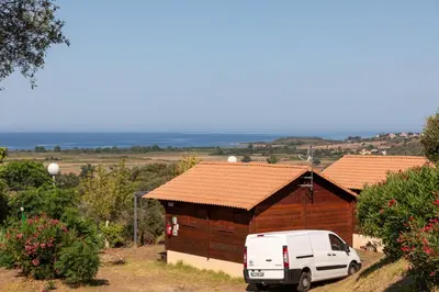 a white van parked in front of a building at Camping Les Couchants in Casaglione