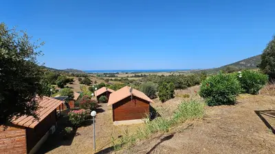 an aerial view of a house with mountains in the background at Camping Les Couchants in Casaglione