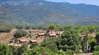 an aerial view of a farm with mountains in the background at Camping Les Couchants in Casaglione