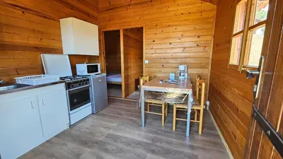 a kitchen with a table and a stove top oven at Camping Les Couchants in Casaglione