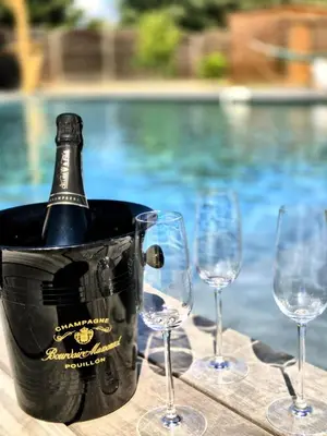a bottle of wine in a bucket next to four wine glasses at A Bella Gaia in Cauro