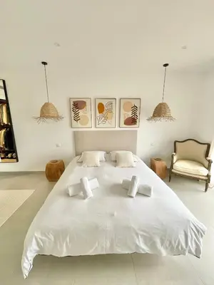 a white bedroom with a large white bed and a chair at Villa vue montagne - 8 pers in Sotta