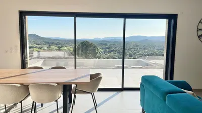 a dining room with a table and chairs and a large window at Villa vue montagne - 8 pers in Sotta