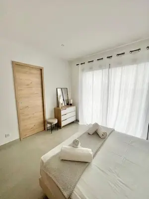 a white bedroom with a bed with two towels on it at Villa vue montagne - 8 pers in Sotta