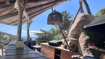a porch of a house with a wooden deck at Secluded Villa With Sea View In Palombaggia in Porto-Vecchio