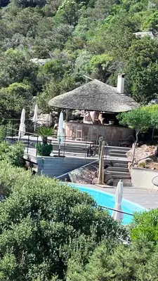 a resort with a swimming pool and a building at Secluded Villa With Sea View In Palombaggia in Porto-Vecchio