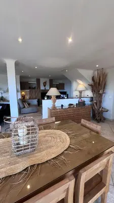 a living room with a table and a living room at Secluded Villa With Sea View In Palombaggia in Porto-Vecchio