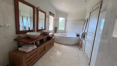 a large bathroom with two sinks and a tub and a tubermott at Secluded Villa With Sea View In Palombaggia in Porto-Vecchio