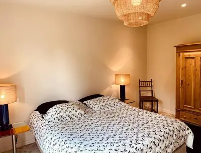 a bedroom with a bed and two lamps and a chair at Chambre Cosy dans villa de standing avec piscine in Porto-Vecchio