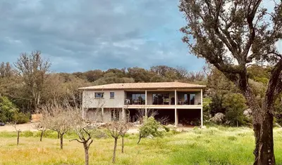 a house in the middle of a field at Chambre Cosy dans villa de standing avec piscine in Porto-Vecchio