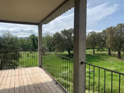 a porch with a view of a field and trees at Chambre Cosy dans villa de standing avec piscine in Porto-Vecchio