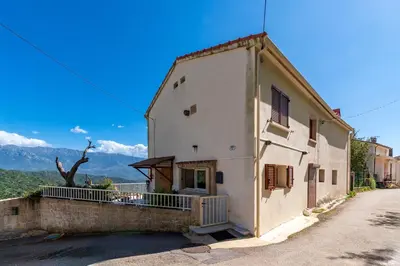 a white building with a balcony on a street at Casa Ultima - Superbe vue proche Ajaccio in Sarrola-Carcopino