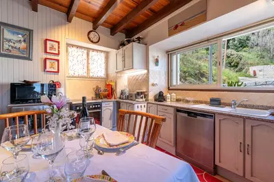 a kitchen with a table with wine glasses on it at Casa Ultima - Superbe vue proche Ajaccio in Sarrola-Carcopino