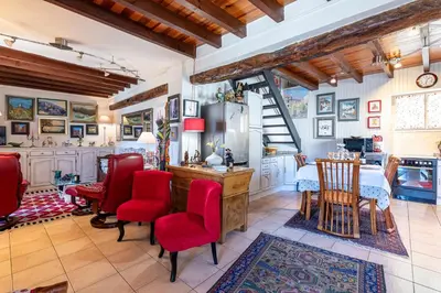 a kitchen and dining room with red chairs and a table at Casa Ultima - Superbe vue proche Ajaccio in Sarrola-Carcopino