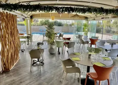 a restaurant with tables and chairs and a pool at Cala Serena Saint Cyprien in Lecci