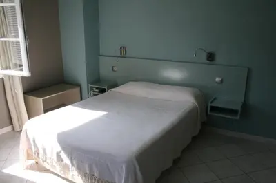 a bedroom with a white bed in a blue room at Le Refuge Orezza in Piedicroce