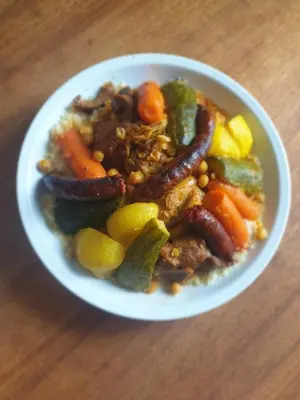 a bowl of food with sausage and vegetables on a table at Le Refuge Orezza in Piedicroce