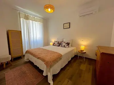 a bedroom with a bed with two lamps and a window at Charmant appartement 50 m Plage in Ajaccio