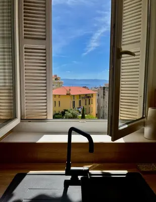 a kitchen window with a view of a city at Charmant appartement 50 m Plage in Ajaccio