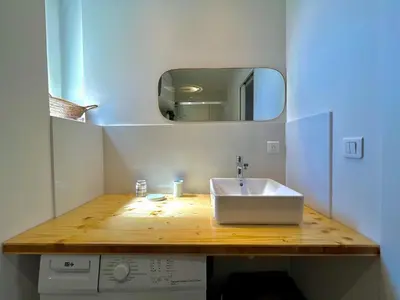 a bathroom with a white sink and a mirror at Charmant appartement 50 m Plage in Ajaccio