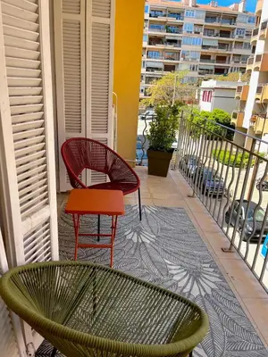 a balcony with two chairs and a red table at Charmant appartement 50 m Plage in Ajaccio