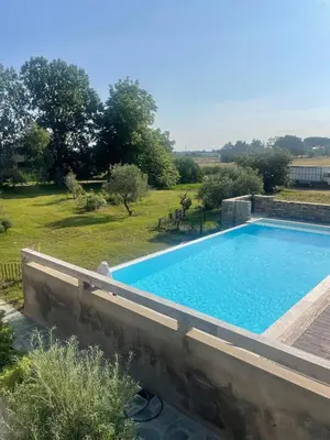 a large swimming pool in a yard with a field at Joli T1 à ne pas manquer in Borgo