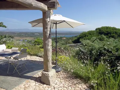 a patio with an umbrella and a table and chairs at Boccamanza in Bonifacio