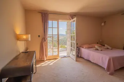 a bedroom with a bed and a sliding glass door at Sud-corse bavella location montagne et mer in Sorbollano
