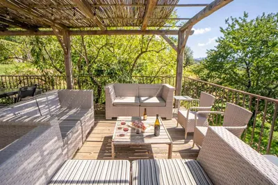 a patio with chairs and a table on a deck at Sud-corse bavella location montagne et mer in Sorbollano
