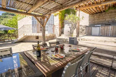 a table with a bottle of wine on a patio at Sud-corse bavella location montagne et mer in Sorbollano
