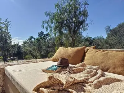a couch with a book and a hat on it at Villas Inamorata in Lecci
