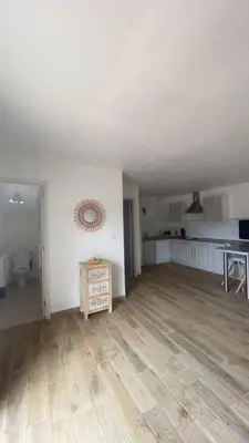 an empty living room with white walls and wooden floors at Le Petit paradis in Aregno