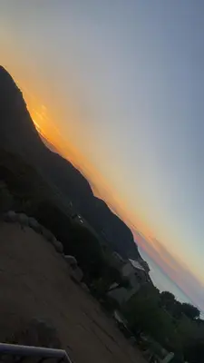 a sunset over a beach with a body of water at Le Petit paradis in Aregno