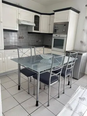 a kitchen with a glass table and some chairs at CHARMANT T3 Pietralba in Ajaccio