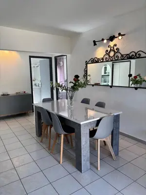 a dining room with a table and chairs and a mirror at CHARMANT T3 Pietralba in Ajaccio