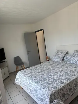 a bedroom with a bed and a chair at CHARMANT T3 Pietralba in Ajaccio
