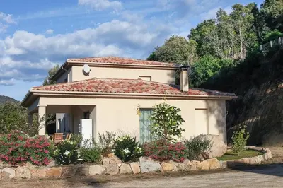 a small white house with flowers in front of it at Villa pour 8 avec piscine in Compoli