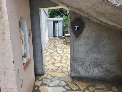 a hallway with a stone floor with a sign on the wall at Appartement calme, authentique et spacieux au pied du GR20 in Calenzana