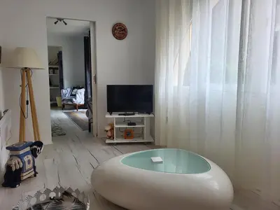 a living room with a large white ottoman at Appartement calme, authentique et spacieux au pied du GR20 in Calenzana