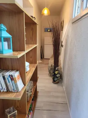 a hallway with wooden shelves and a vase with a plant at Appartement calme, authentique et spacieux au pied du GR20 in Calenzana