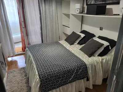 a bedroom with a bed with black and white pillows at Appartement calme, authentique et spacieux au pied du GR20 in Calenzana