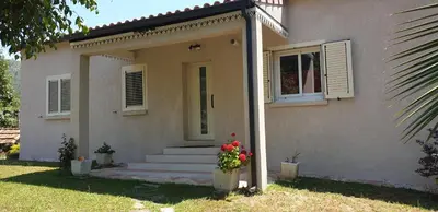 a house with a porch with flowers in front of it at Villa Pastriccialone in Afa