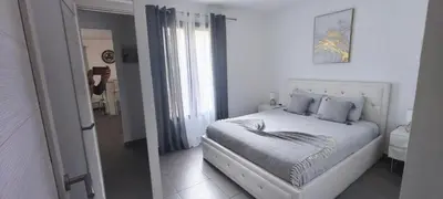 a woman taking a picture of a bed in a bedroom at Résidence privée avec piscine à Bonifacio in Bonifacio