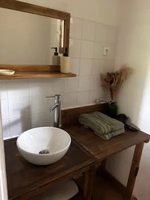 a bathroom with a white bowl sink on a wooden counter at Chambre cosy à 5 min de la plage in Viagenti