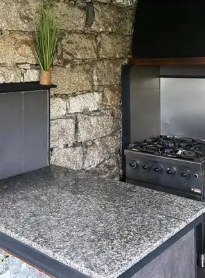 a kitchen with a stove and a stone wall at Chambre cosy à 5 min de la plage in Viagenti