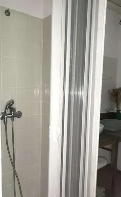 a shower with a glass door in a bathroom at Chambre cosy à 5 min de la plage in Viagenti
